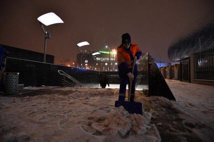 Москва. Дворник чистит снег на одной из улиц города во время снегопада.