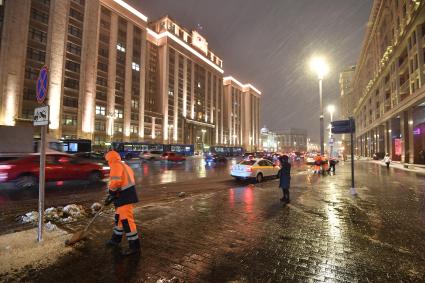 Москва. Дворник чистит снег на улице Охотный ряд.