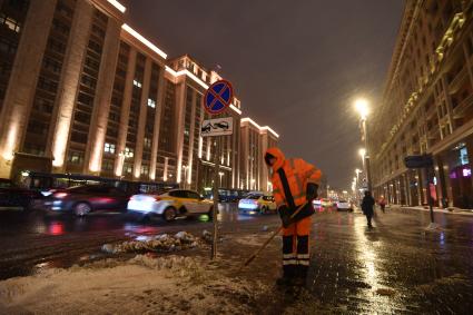 Москва. Дворник чистит снег на улице Охотный ряд.