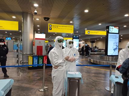Москва. Сотрудники санитарно-карантинного пункта в спецкостюмах и перчатках проверяют пассажиров, прибывших в аэропорт Шереметьево из Китая.
