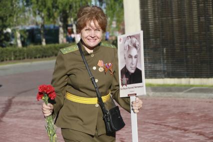 Барнаул. Женщина с цветами  у мемориального памятника  Защитникам Отечества в Великой Отечественной Войне.