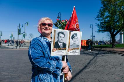 Санкт-Петербург. Женщина с портретами участников ВОВ на набережной в Санкт-Петербурге во время празднования Дня Победы.