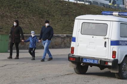 Барнаул. Родители с ребенком в защитных масках идут по улице.