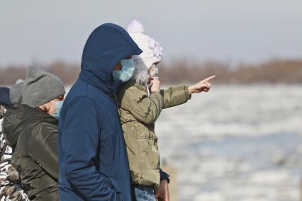 Барнаул. Родители с ребенком в защитных масках смотрят на ледоход на реке Обь.