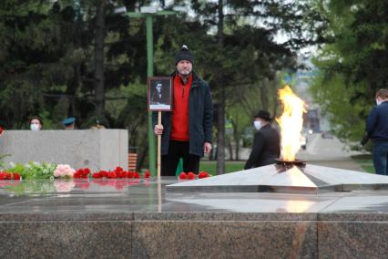 Иркутск. Мужчина у мемориала`Вечный огонь` во время празднования Дня Победы.