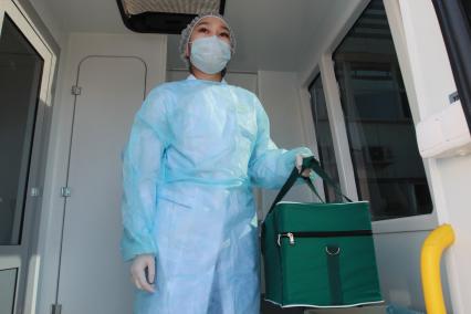 Иркутск. Медицинский работник держит в руках термоконтейнер с мазками на ковид для лабораторного исследования.