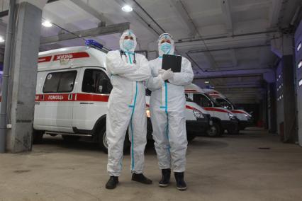 Иркутск. Медицинские работники в защитных костюмах у автомобиля скорой помощи.