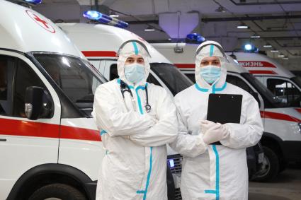 Иркутск. Медицинские работники в защитных костюмах у автомобиля скорой помощи.