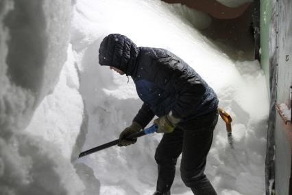 Норильск. Мужчина чистит снег после снегопада.