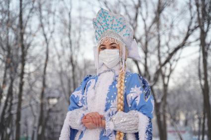 Самара. Девушка в костюме Снегурочки позирует в зимнем парке.