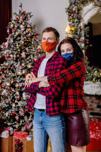 Челябинск. Молодой человек с девушкой в защитных масках встречают Новый год дома.