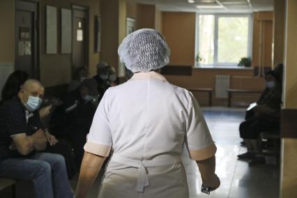 Барнаул. Медицинский работник идет по коридору приемного отделения онкоцентра.