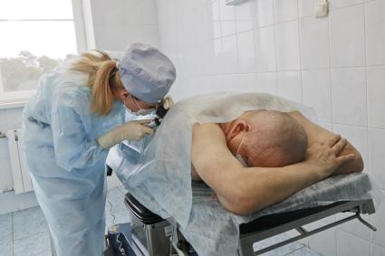 Барнаул. Врач берет биопсию у пациента в онкоцентре.