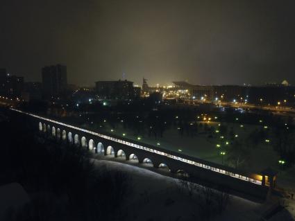 Москва.  Вид сверху на вечерний город и подсветку в парке Ростокинского акведука.