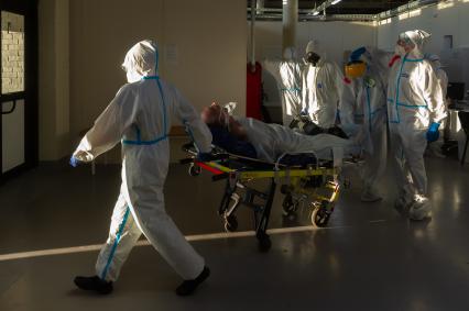 Санкт-Петербург.  Медицинские работники транспортируют пациента во временном госпитале для больных COVID-19, организованном в выставочном комплексе `Ленэкспо`.