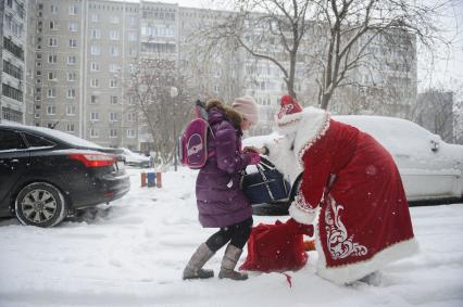 Екатеринбург. Благотворительный фонд \'Дорогами добра\'. Дамир Юсупов - Герой России, пилот авиакомпании \'Уральские авиалинии\' посадивший пассажирский самолет Airbus A321 в кукурузном поле, в костюме деда мороза, поздравляет ребенка с новым годом.