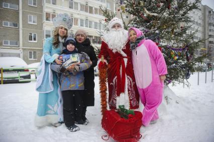 Екатеринбург. Благотворительный фонд \'Дорогами добра\'. Дамир Юсупов - Герой России, пилот авиакомпании \'Уральские авиалинии\' посадивший пассажирский самолет Airbus A321 в кукурузном поле, в костюме деда мороза, поздравляет ребенка с новым годом.