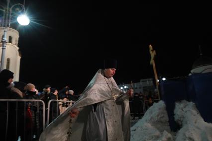 Красноярск. Батюшка освещает воду во время праздника Крещения Господне у храма Рождества Христова.