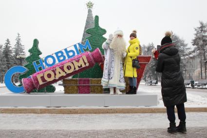 Иркутск. Байкальский Дед Мороз фотографируется с девушкой на одной из улиц города.