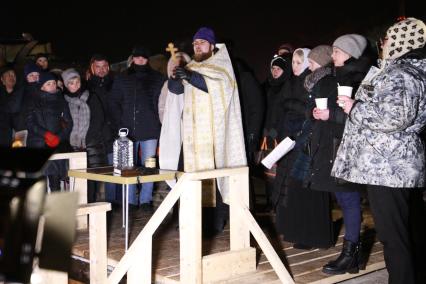 Владивосток. Батюшка освещает воду во время праздника Крещения Господне на пляже Юбилейный.