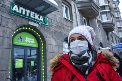 Новосибирск. Девушка в медицинской маске около аптеки.