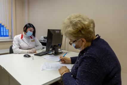 Санкт-Петербург. Женщина заполняет согласение на вакцинацию от коронавирусной инфекции в поликлинике N102.