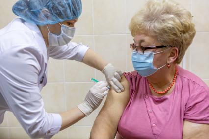 Санкт-Петербург. Медсестра делает женщине прививку вакциной `Гам-Ковид-Вак` от коронавирусной инфекции в поликлинике N102.