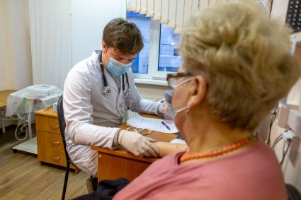 Санкт-Петербург. Врач проводит осмотр женщины перед вакцинацией от коронавирусной инфекции в поликлинике N102.