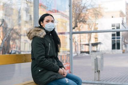 Самара. Девушка в медицинской маске на автобусной остановке.