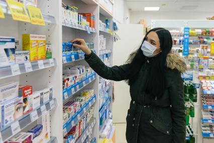 Самара. Девушка в медицинской маске в аптеке.