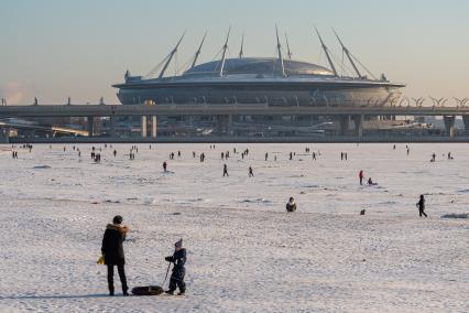 Санкт-Петербург. Горожане катаются на импровизированном катке Финского залива на фоне стадиона `Газпром-Арена`.