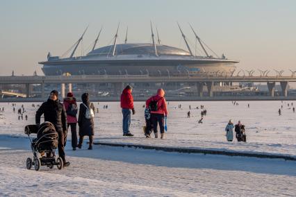 Санкт-Петербург. Горожане катаются на импровизированном катке Финского залива на фоне стадиона `Газпром-Арена`.