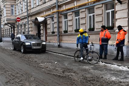 Москва. Сотрудники коммунальных служб и доставки еды на улице города.