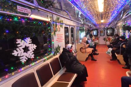 Москва.    Пассажиры в вагоне новогоднего поезда Московского метрополитена.