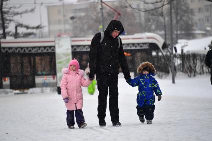 Москва.  Мужчина с детьми на одной из улиц города.