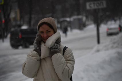 Москва. Девушка во время снегопада на одной из улиц города.