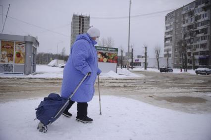 Екатеринбург. Бабушка обходит дорогу затопленную водой, после прорыва водопровода, во время зимних морозов