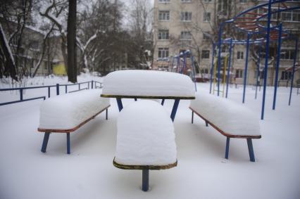 Екатеринбург. Столик и скамейки на детской площадке под слоем снега, во время зимних морозов