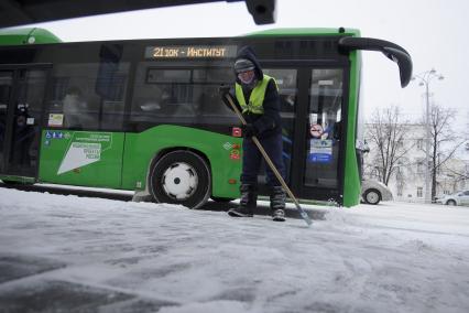 Екатеринбург. Дворник очищает от наледи остановку общественного транспорта, во время зимних морозов