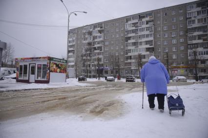 Екатеринбург. Бабушка обходит дорогу затопленную водой, после прорыва водопровода, во время зимних морозов