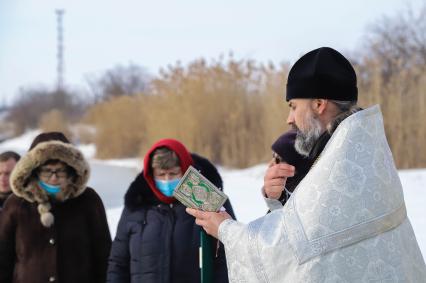 Краснодарский край. Тимашевск. Священнослужитель совершает обряд освящения воды в праздник Крещения Господня.