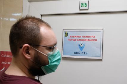 Санкт-Петербург. Мужчина у прививочного кабинета перед вакцинацией от коронавирусной инфекции в поликлинике.