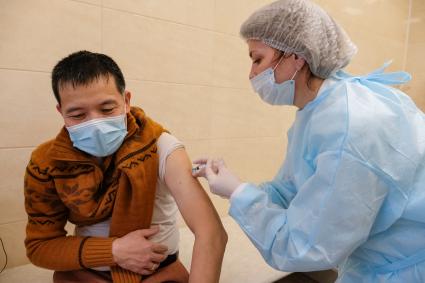 Санкт-Петербург. Медсестра делает мужчине прививку вакциной `Гам-Ковид-Вак` от коронавирусной инфекции в поликлинике.