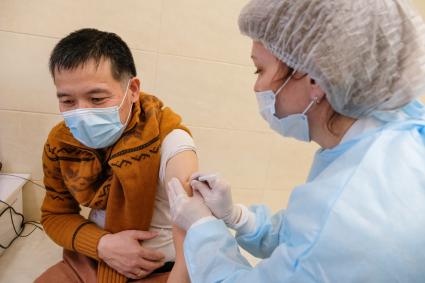 Санкт-Петербург. Медсестра делает мужчине прививку вакциной `Гам-Ковид-Вак` от коронавирусной инфекции в поликлинике.