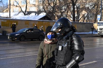 Москва.  Сотрудник полиции во время задержания участницы акции в поддержку Навального у здания Мосгорсуда, где  будет рассматриваться требование ФСИН о замене условного срока Алексея Навального на реальный.