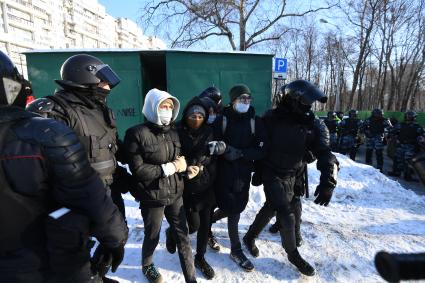 Москва.  Сотрудники полиции во время задержания участниц акции в поддержку Навального у здания Мосгорсуда, где  будет рассматриваться требование ФСИН о замене условного срока Алексея Навального на реальный.