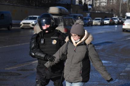 Москва.  Сотрудник полиции во время задержания участницы акции в поддержку Навального у здания Мосгорсуда, где  будет рассматриваться требование ФСИН о замене условного срока Алексея Навального на реальный.