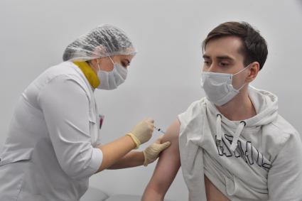 Москва. Медсестра делает мужчине прививку вакциной `Гам-Ковид-Вак` (`Спутник V`) от коронавирусной инфекции COVID-19 в прививочном пункте выездной бригады вакцинации в ТРЦ `Щелковский`.
