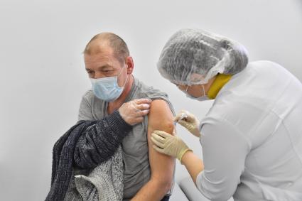Москва. Медсестра делает мужчине прививку вакциной `Гам-Ковид-Вак` (`Спутник V`) от коронавирусной инфекции COVID-19 в прививочном пункте выездной бригады вакцинации в ТРЦ `Щелковский`.