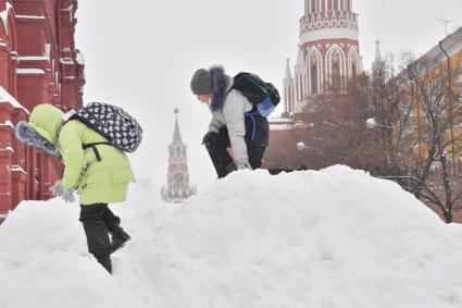 Москва. Дети играют на снежной горке в Кремлевском проезде.